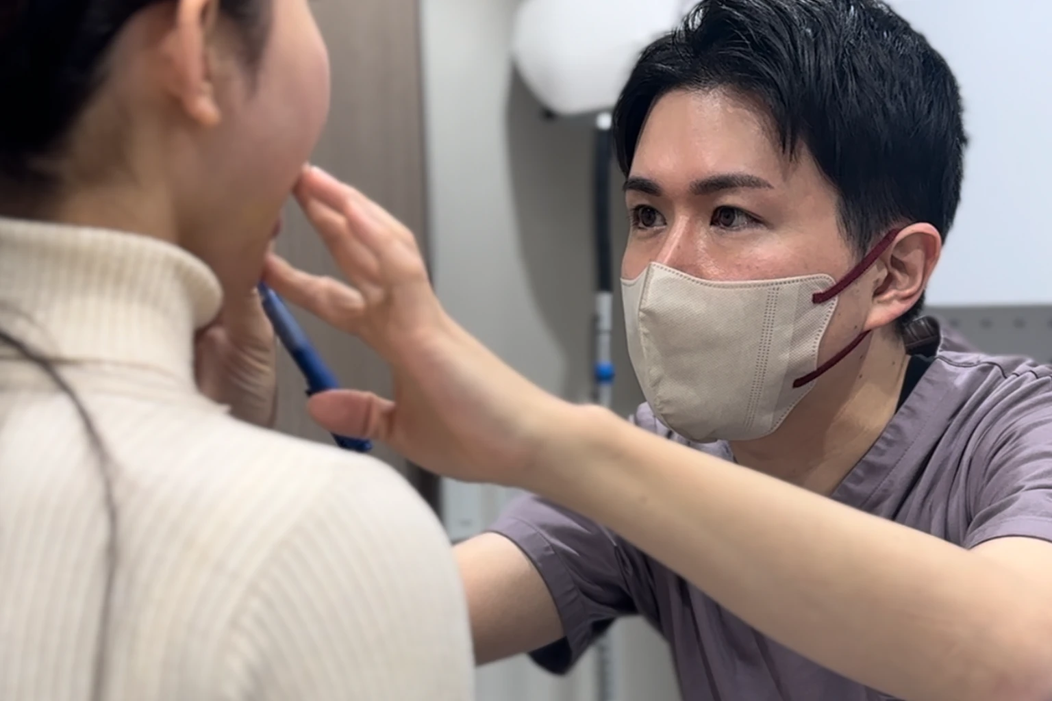 医師が口元を診察し、デザインを確認する診察風景（施術結果を示すものではありません）